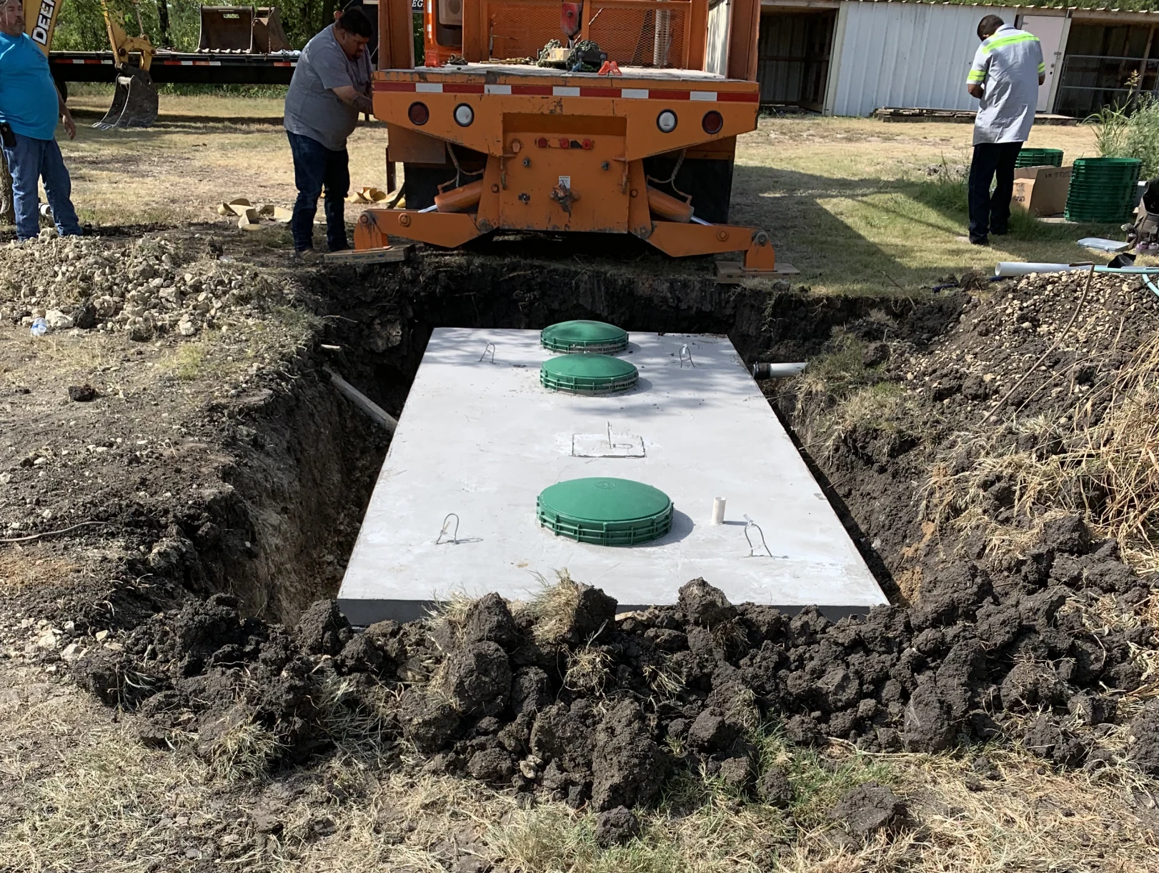 Workers installing underground septic tank
